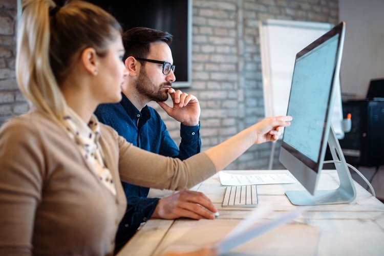 Two people looking into the computer