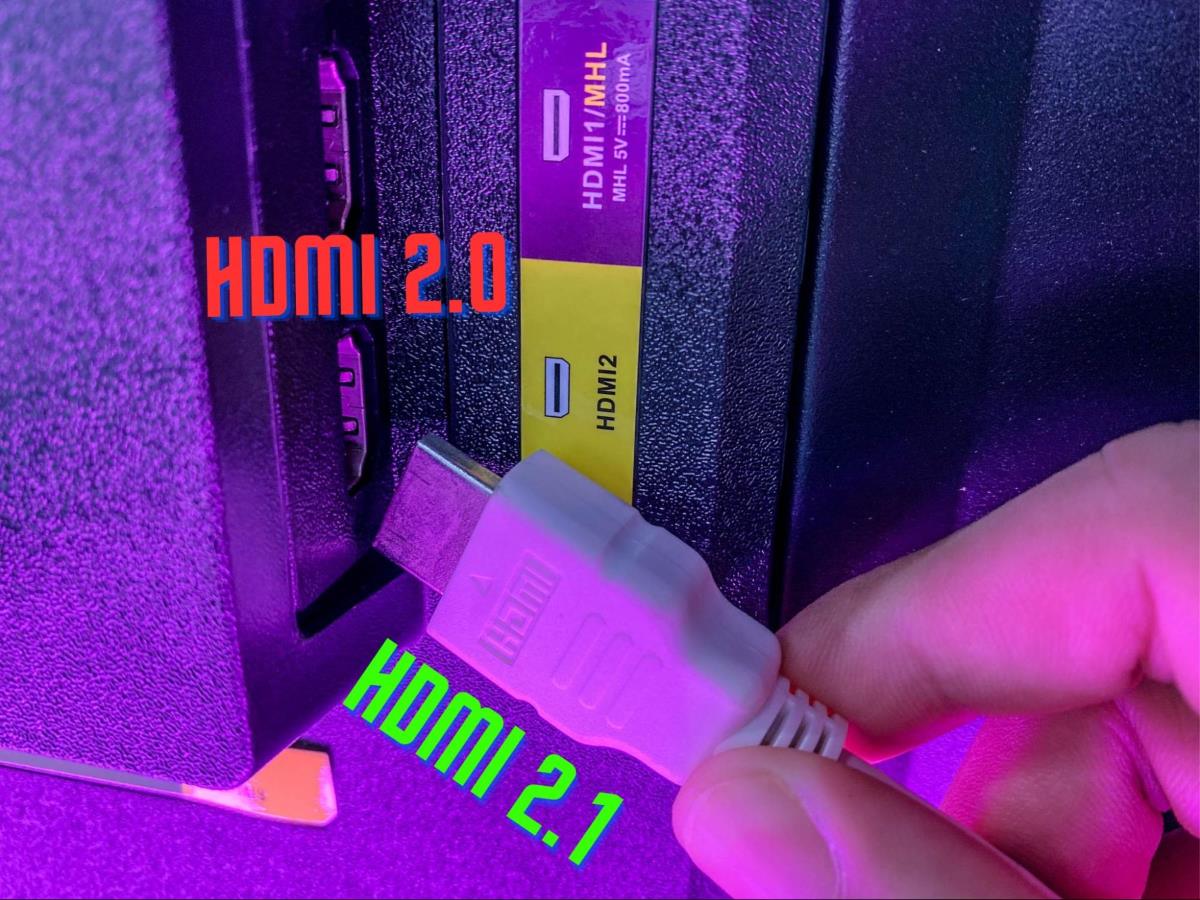 a hand is holding a HDMI 2.1 cable next to a HDMI 2.0 port on a TV