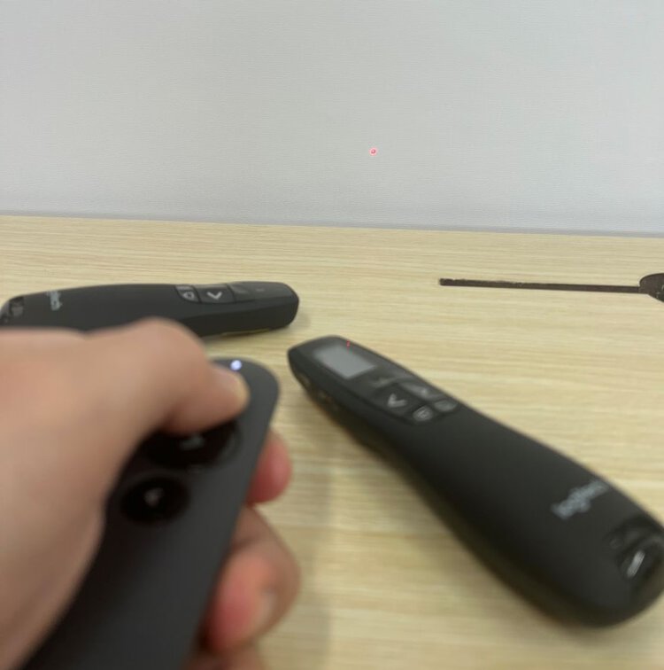 pointer laser is pointing at the projector screen with two logitech laser pointers