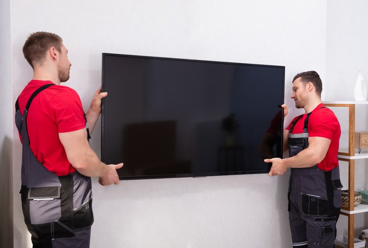 two technician put on a tv on a wall in a hotel