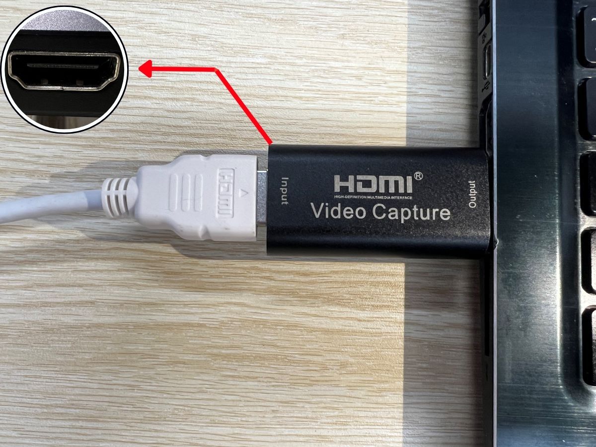 A white HDMI is plugged into the HDMI port of the capture card