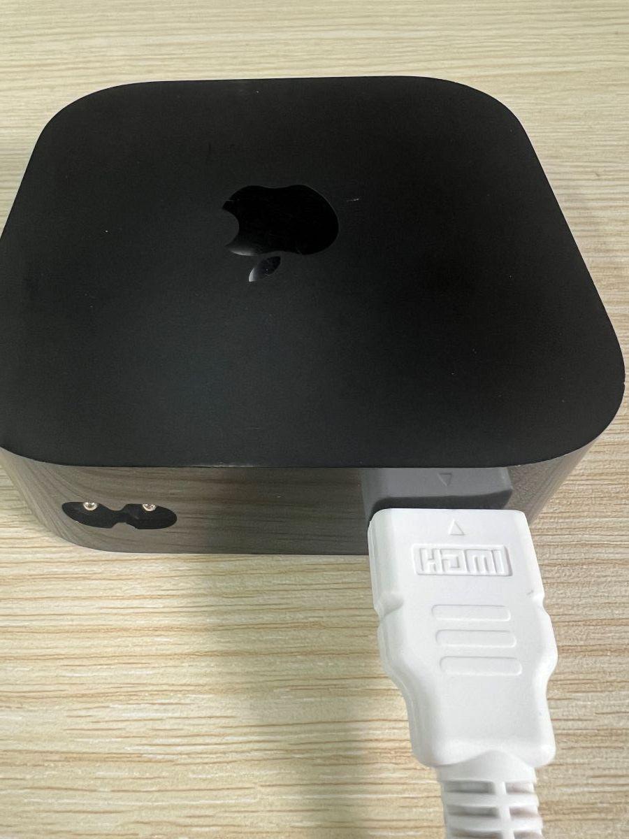 An HDMI cable is plugged to the Apple TV box
