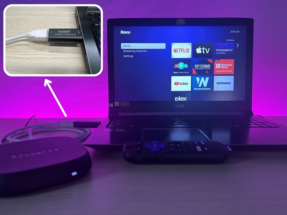 Roku Ultra on a table connected to Asus laptop using HDMI capture card with a pink light background