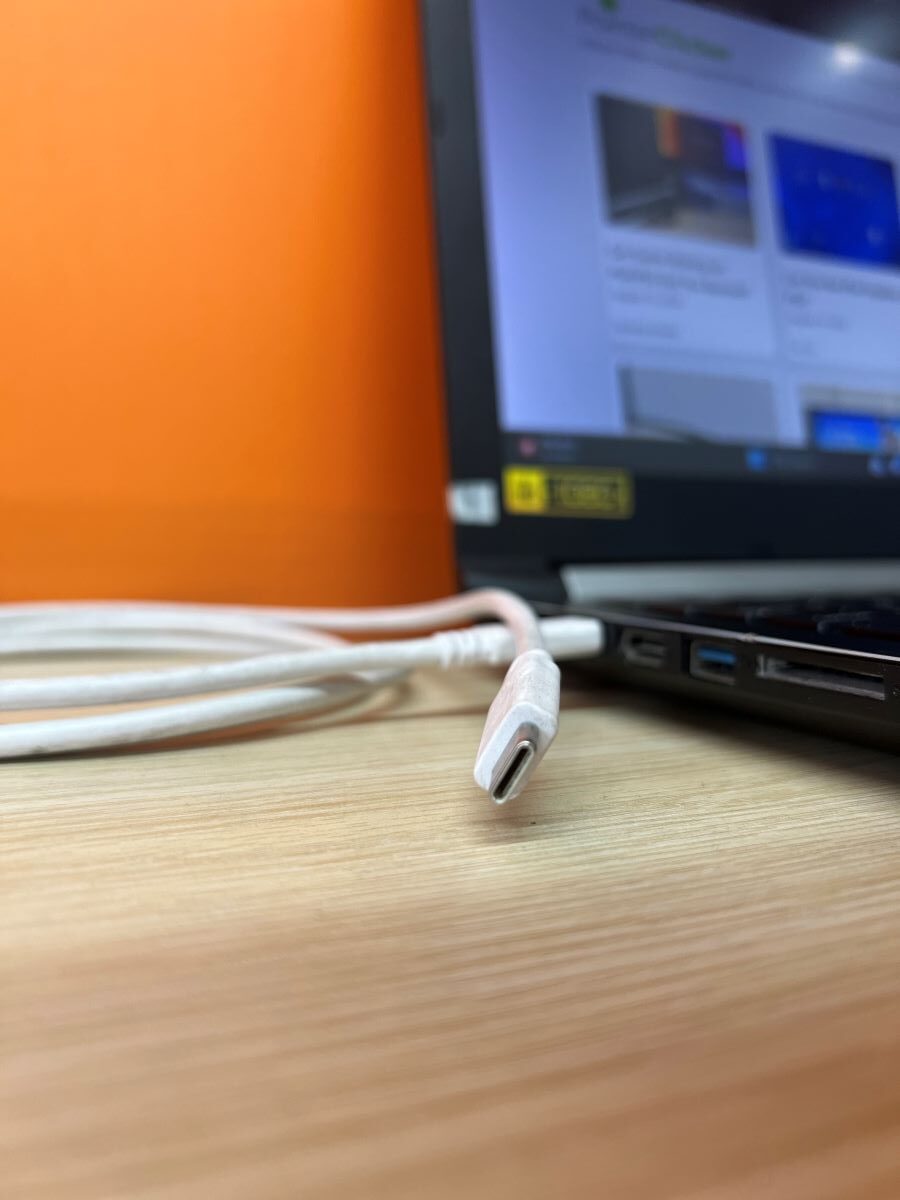 The DP Thunderbolt USB-C is plugged into an Asus laptop and the orange background