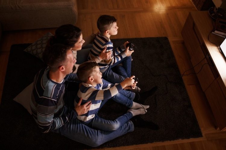 A family of four playing game on TV