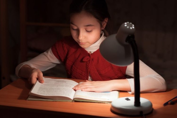A girl studying under the light
