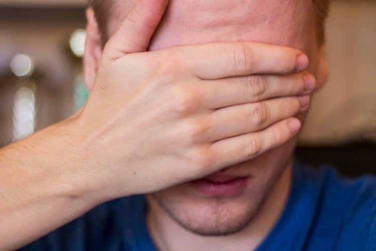 A man covering his eyes