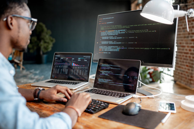 A man using both laptop and monitor