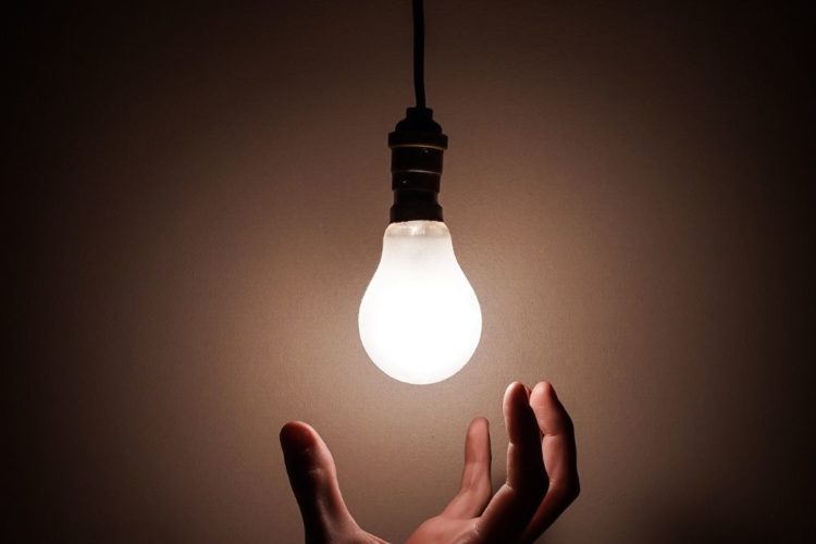 A person touching a light bulb