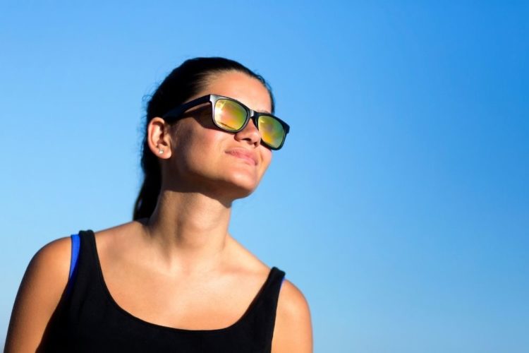 A woman watching the sun with sunglasses