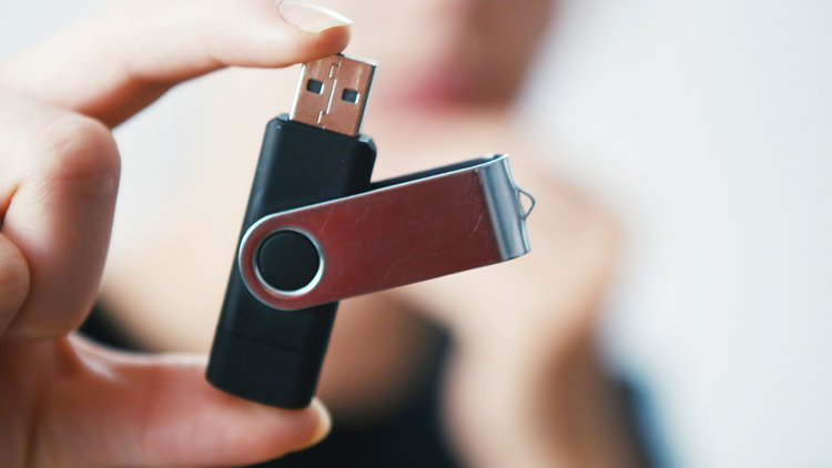 a hand holding Black USB Flash Drive