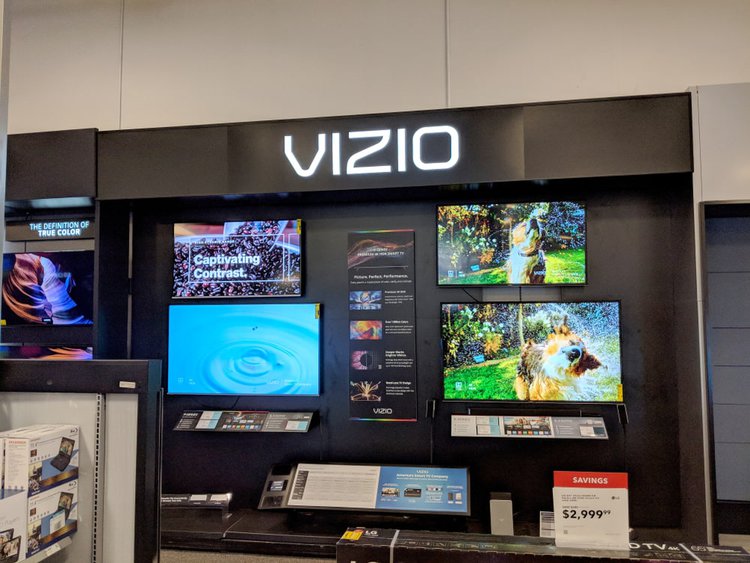 Five Vizio TVs in a showroom