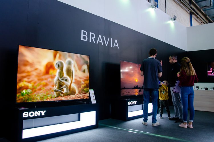 Three young men are buying Sony Bravia TVs