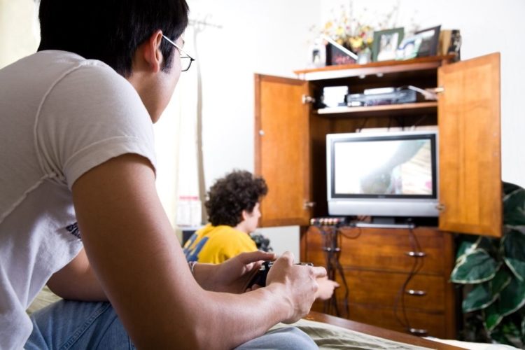 Two boys playing game on TV
