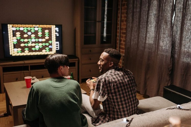 Two friends playing game on TV