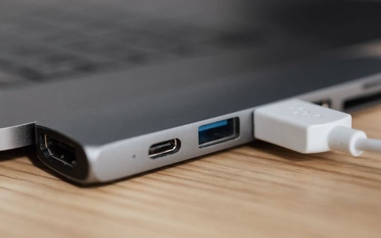 a white USB cable connecting USB port on laptop