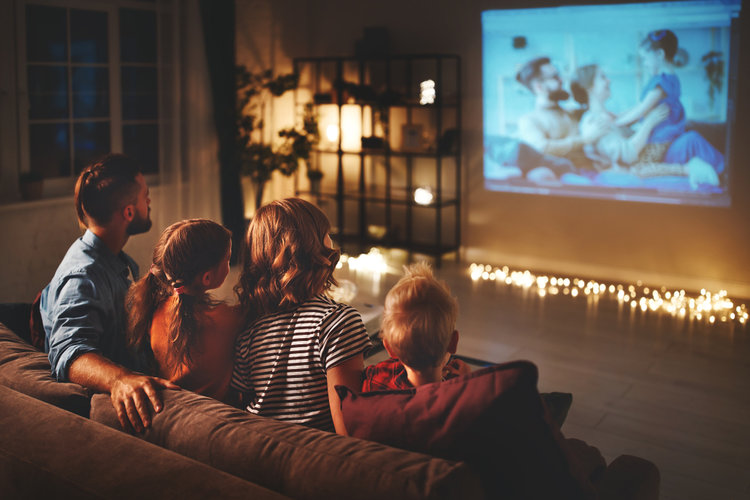 Eine Familie schaut gemeinsam Film auf Projektorleinwand