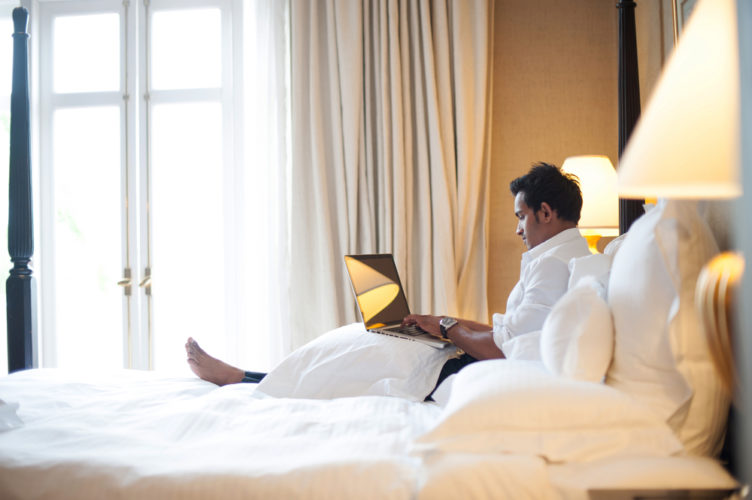A man watching laptop in his hotel room