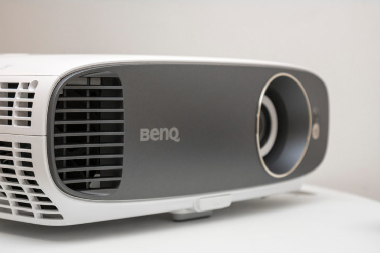 A white BenQ projector on a white table