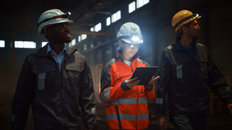 Three people in the construction site with flashlight