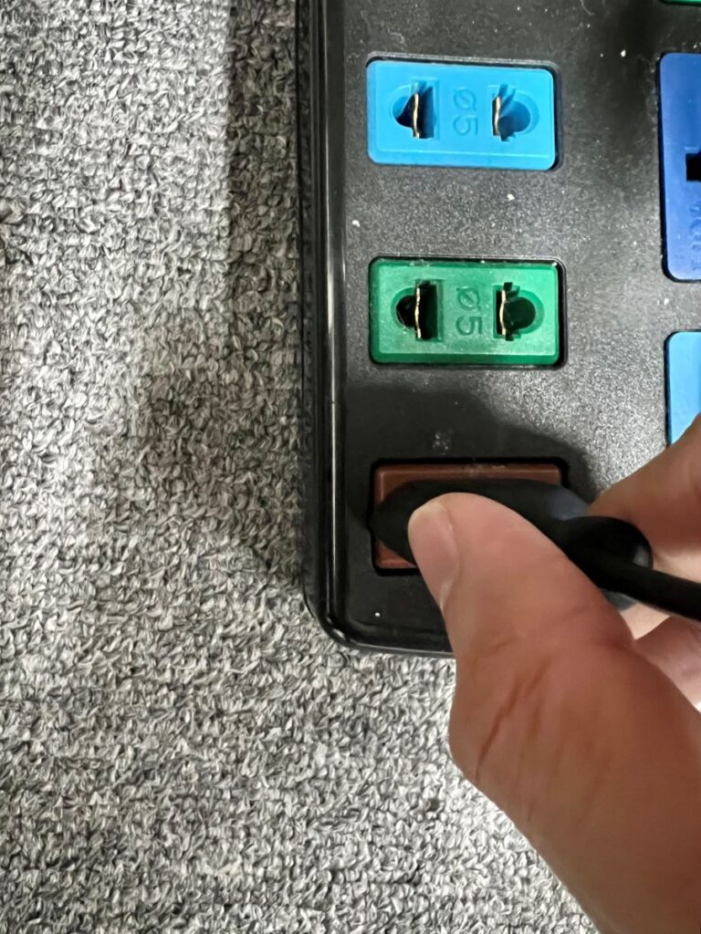 a hand plugging in a power cord