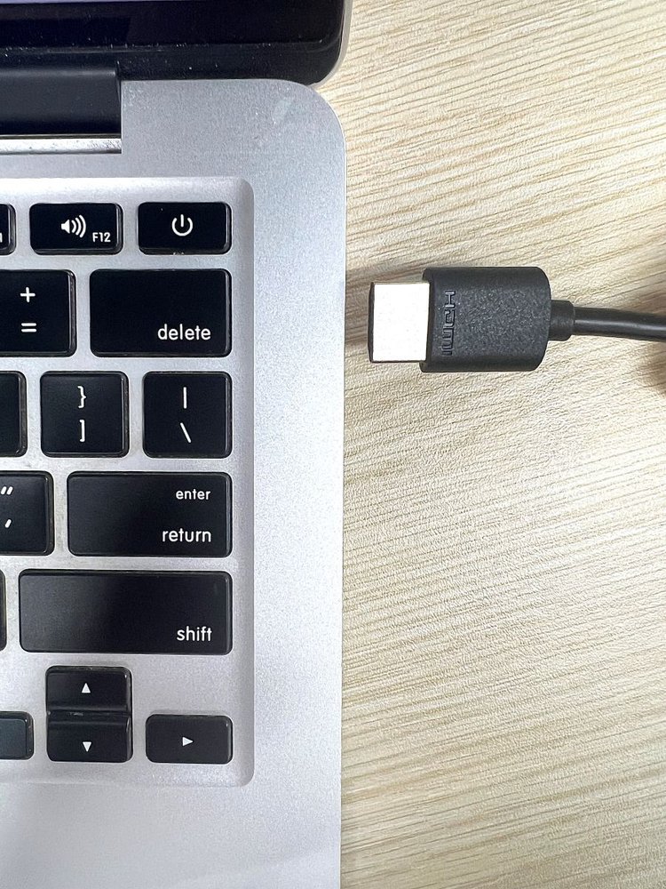 an hdmi cable is plugged into a macbook