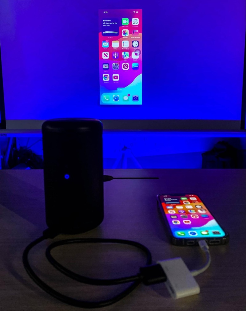 an iPhone screen is wired and mirrored to the Nebula projector