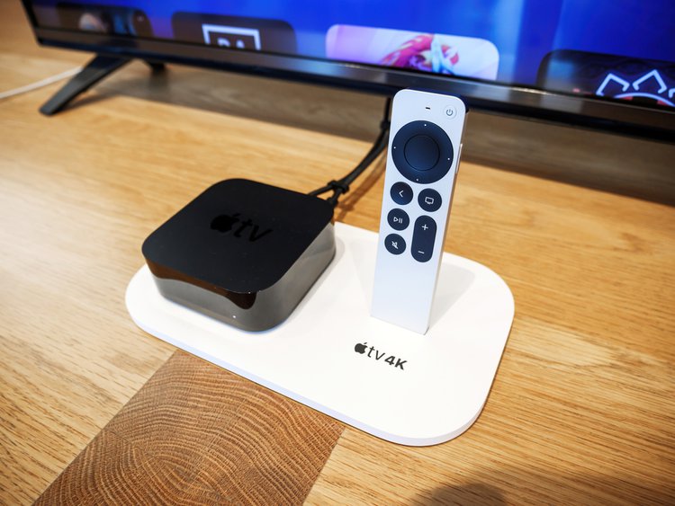 A 4K Apple TV next to a TV and a remote