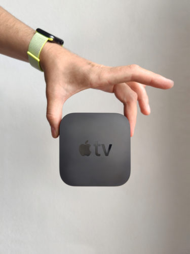 A person holding an Apple TV box