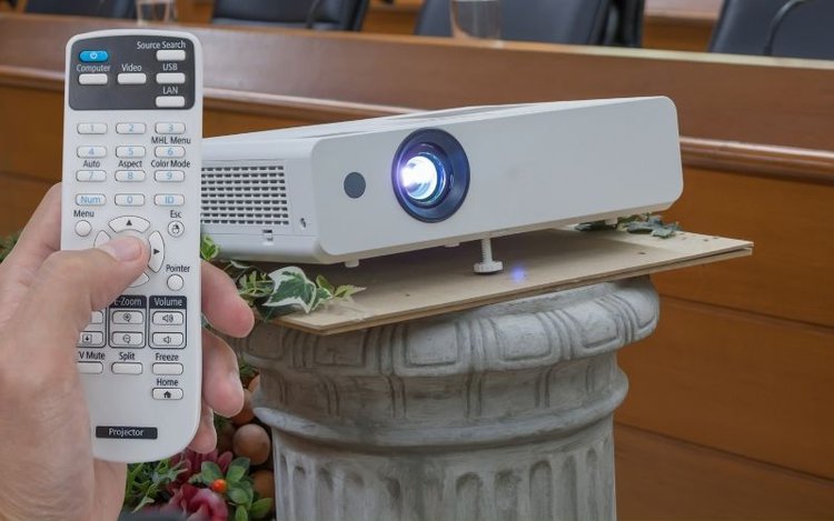 Adjusting and resetting a projector by using a remote