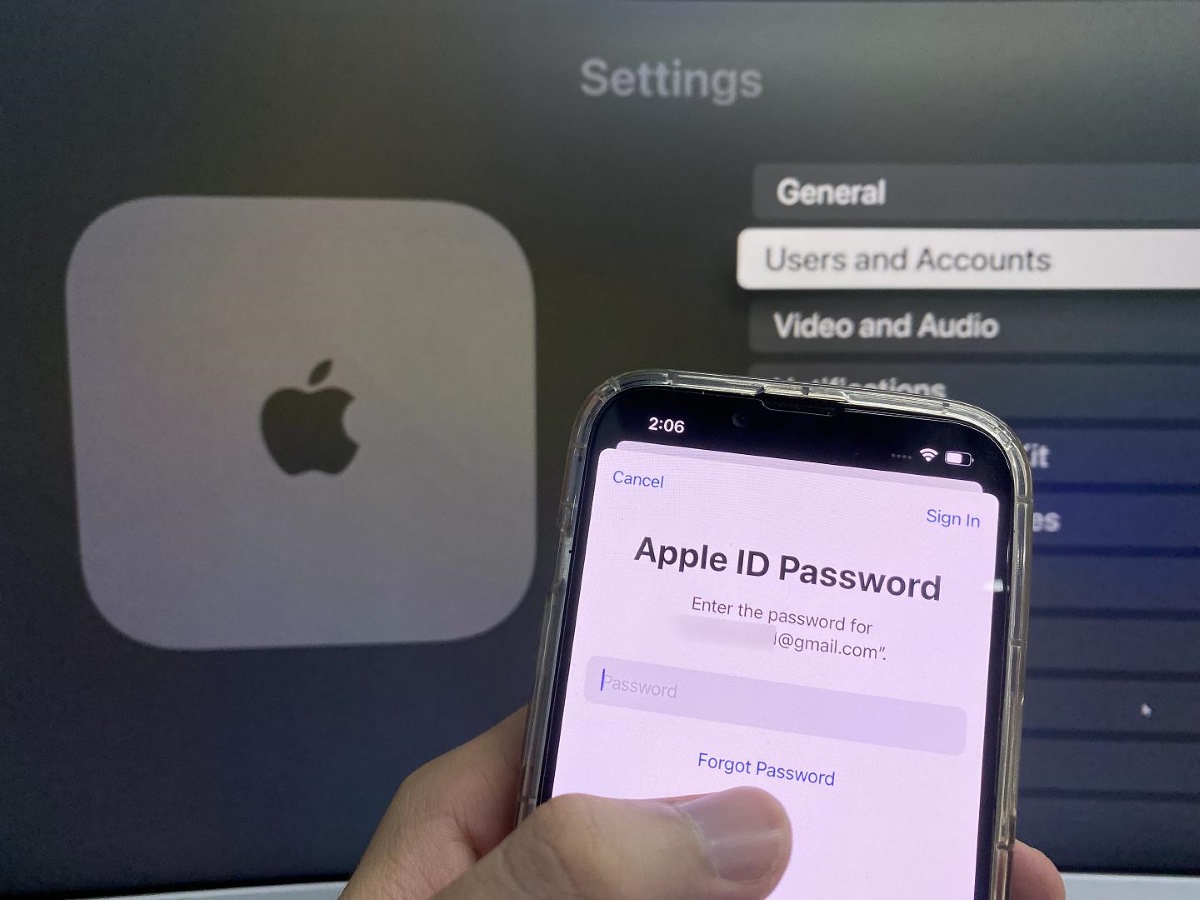 Apple ID password reset screen in front of an Apple TV screen
