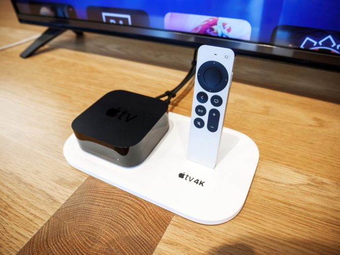 Apple TV box and remote on a wood table