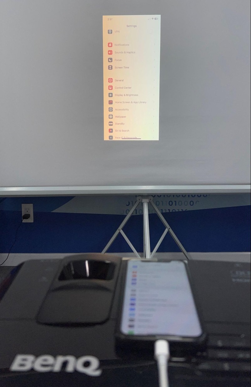 BenQ projector is displaying an iPhone screen via HDMI connection