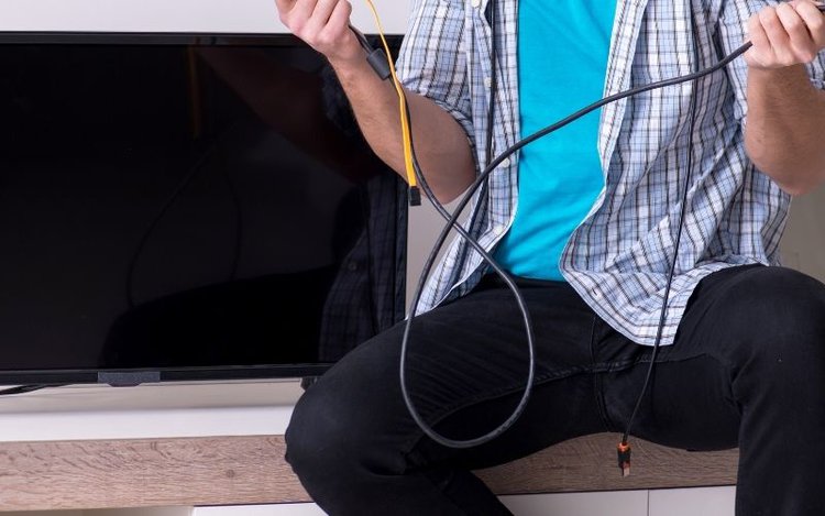 man holding a long HDMI cable