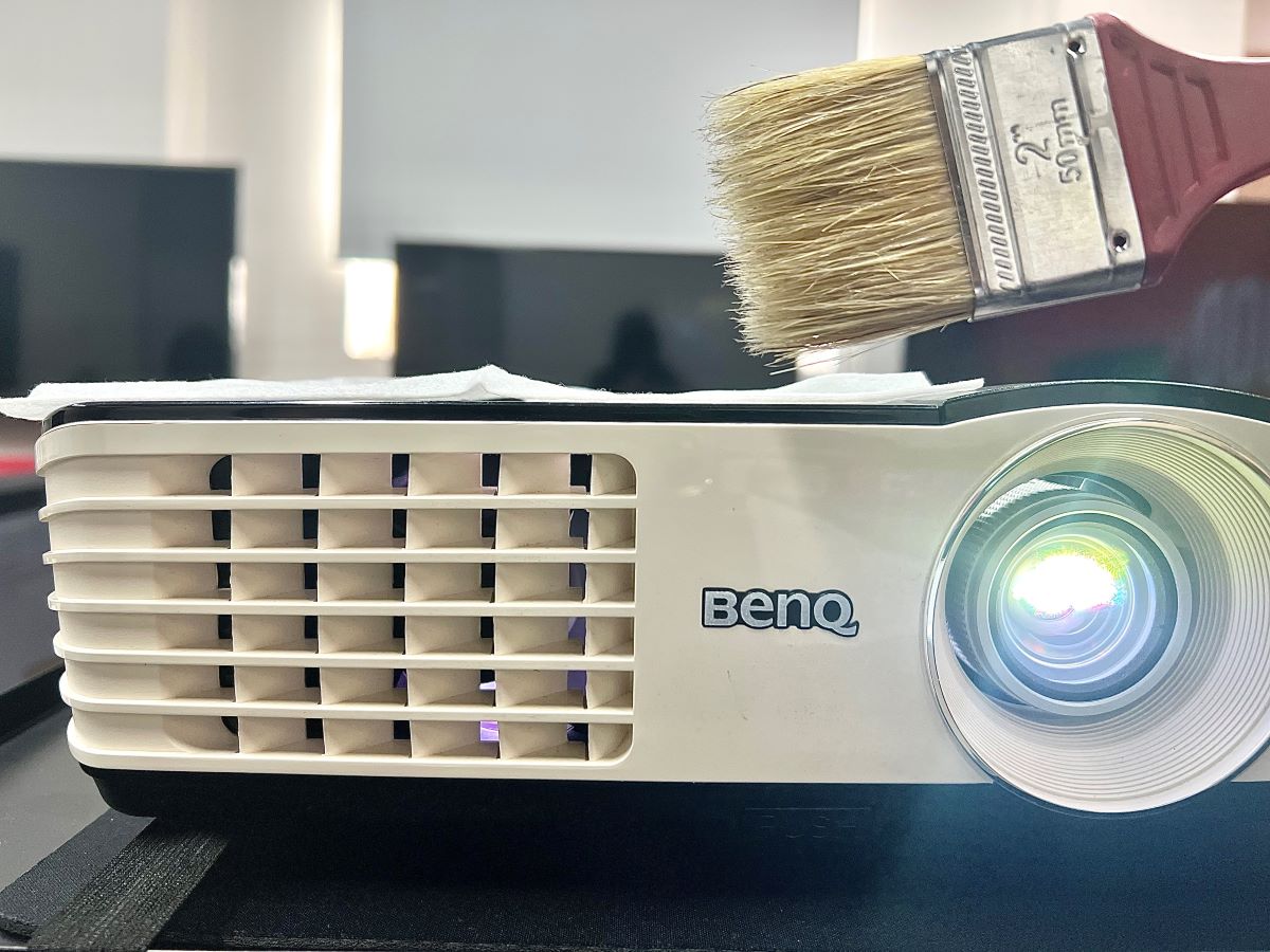 a benq projector looked from front and a brush above it