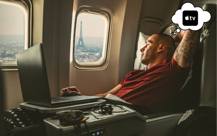 a man is using his laptop on the plane