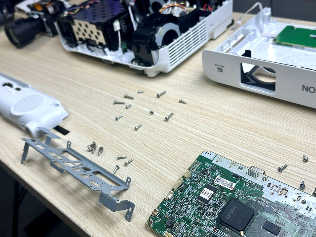 an epson projector is dismantled and spred on the table