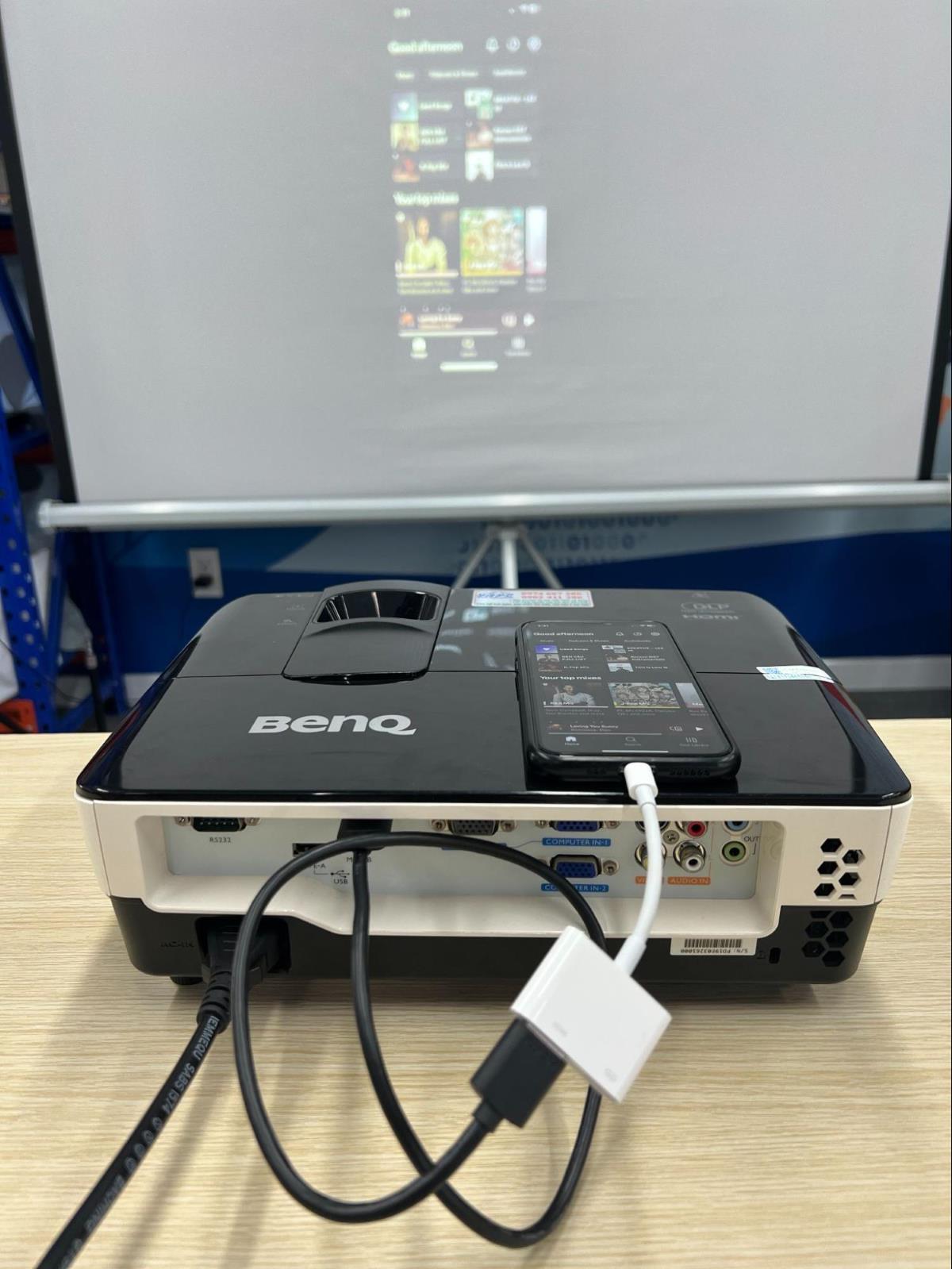 an iPhone is connected to the BenQ projector via HDMI connection