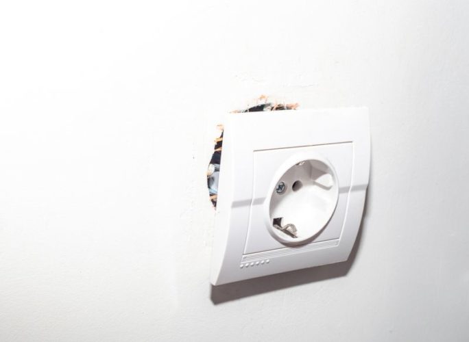 broken electrical socket torn from wall
