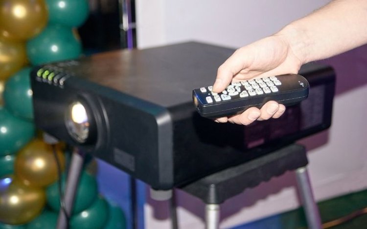 man using a remote control to operate projector