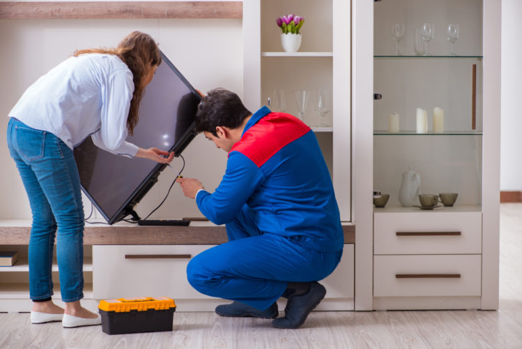 A man repairing a broken TV