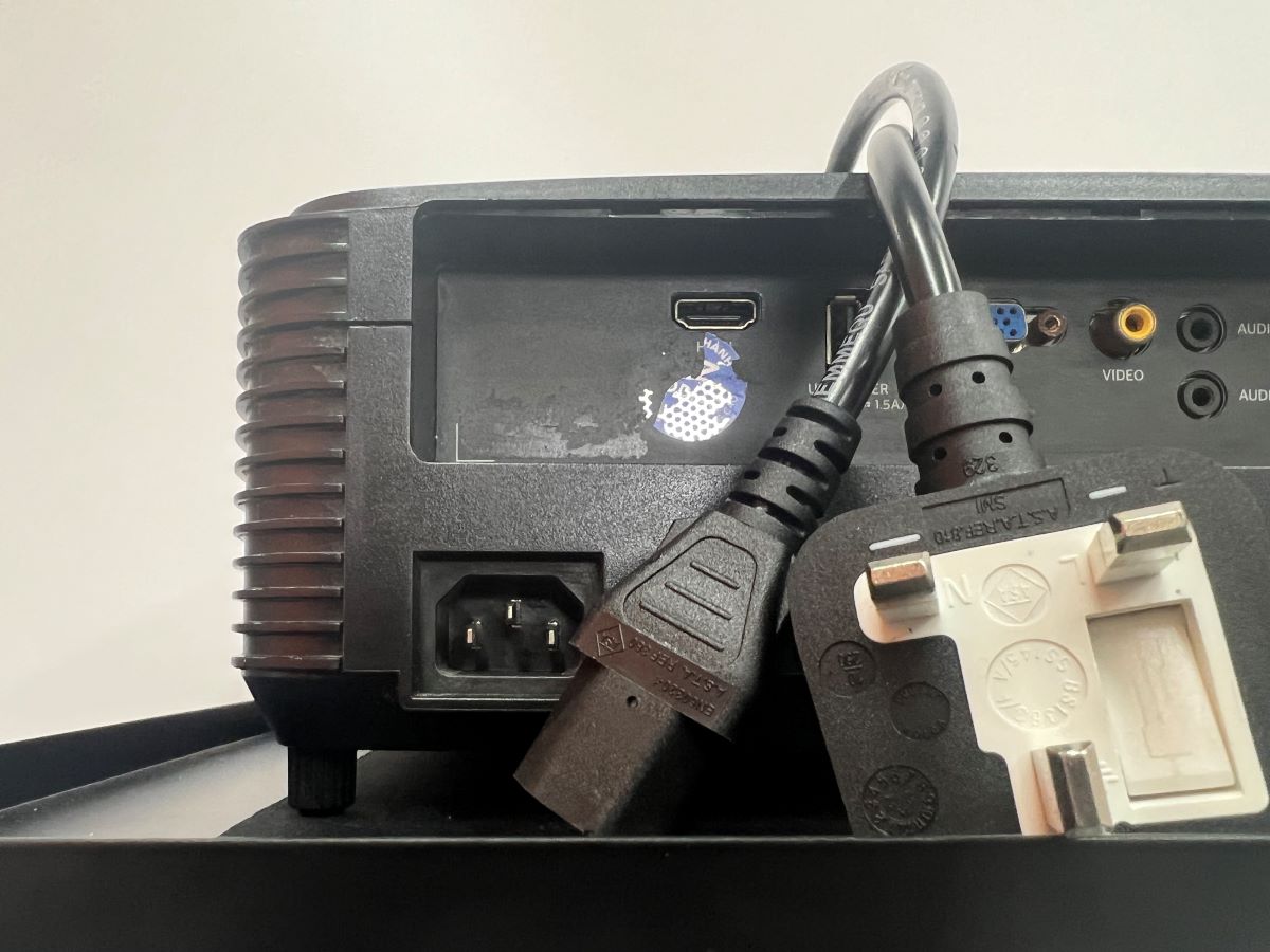 Optoma projector with the power cord together with a white background