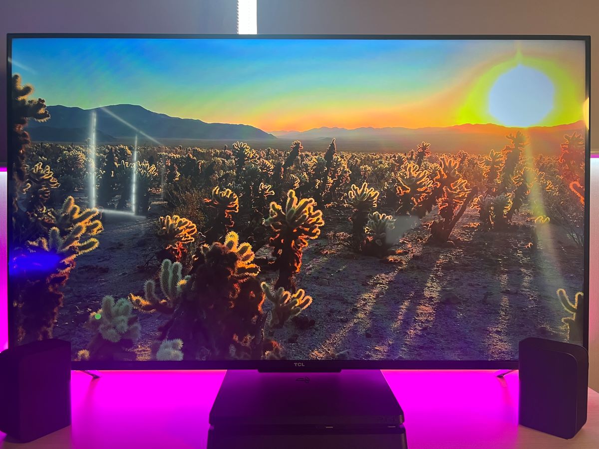 The TCL TV showing a YouTube video with the PS4 and two Vizio speakers