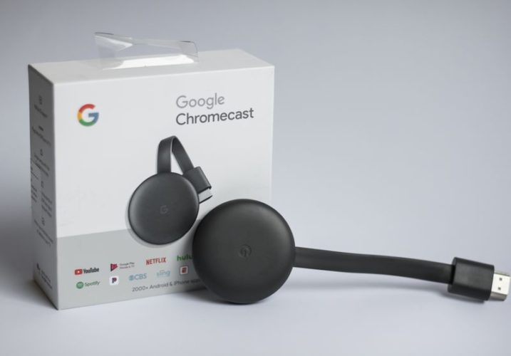 a black Google Chromecast with its original box
