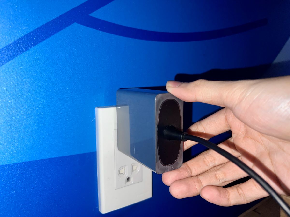 a hand unplugging an xgimi projector's power cord