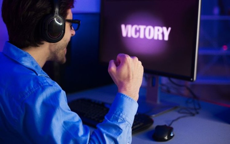 a male games is celebrating his victory on a competitive PC game