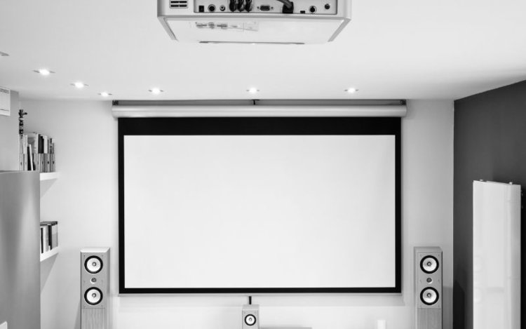 a projector screen in class room with projector and soundbars