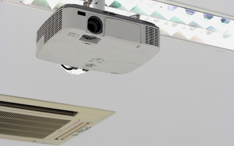 a white projector in ceiling near the cooling system