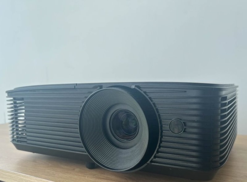 an Optoma projector placed on a table in a rear side view