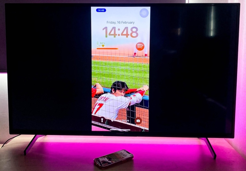 an iPhone lock screen is mirrored on a TV